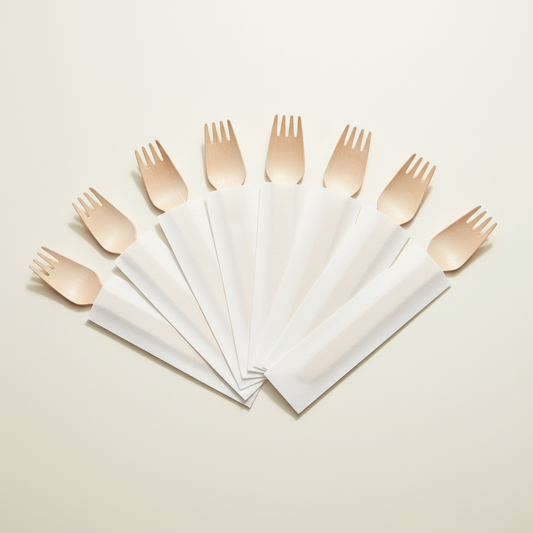 Wooden forks with visible tines in opaque white paper sleeves on a clean white background
